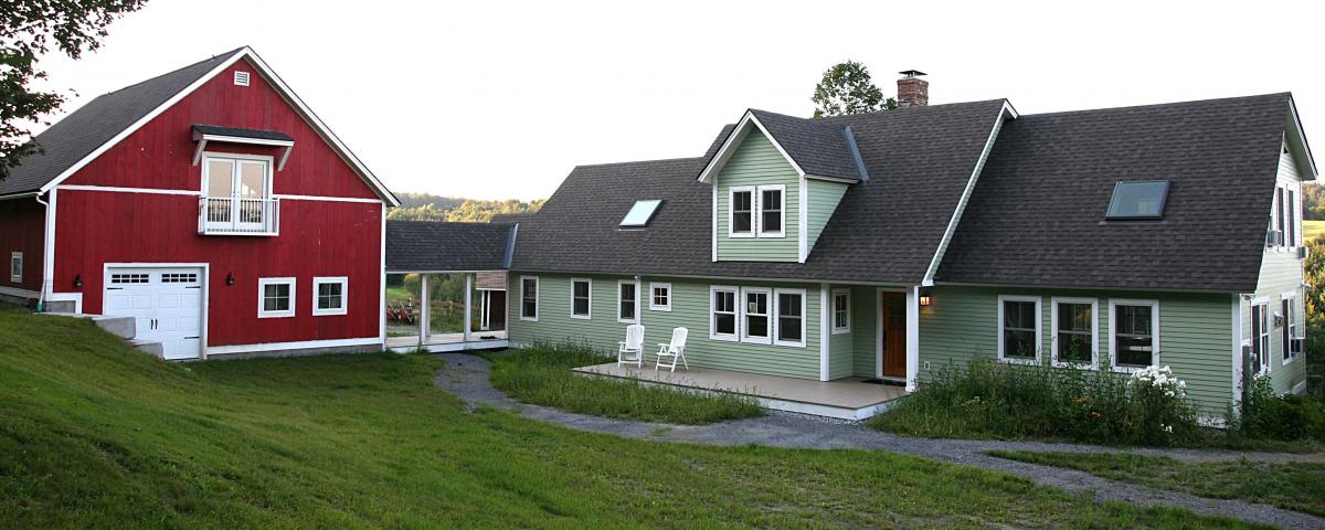 A large remodeled green home and red barn in Central Vermont